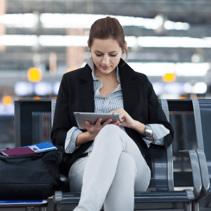 Woman Checking Email on Tablet in Airport