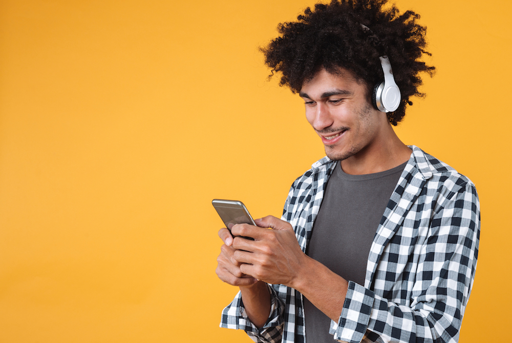 Man holding phone with headphones on