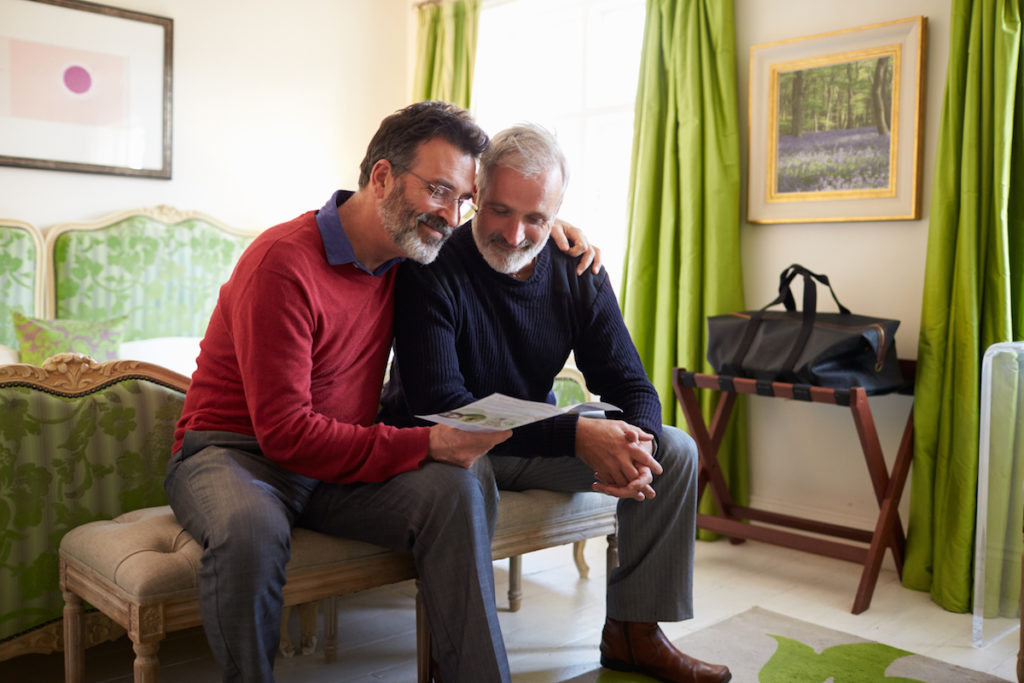 Two Men Reading a Brochure in Their Hotel Room