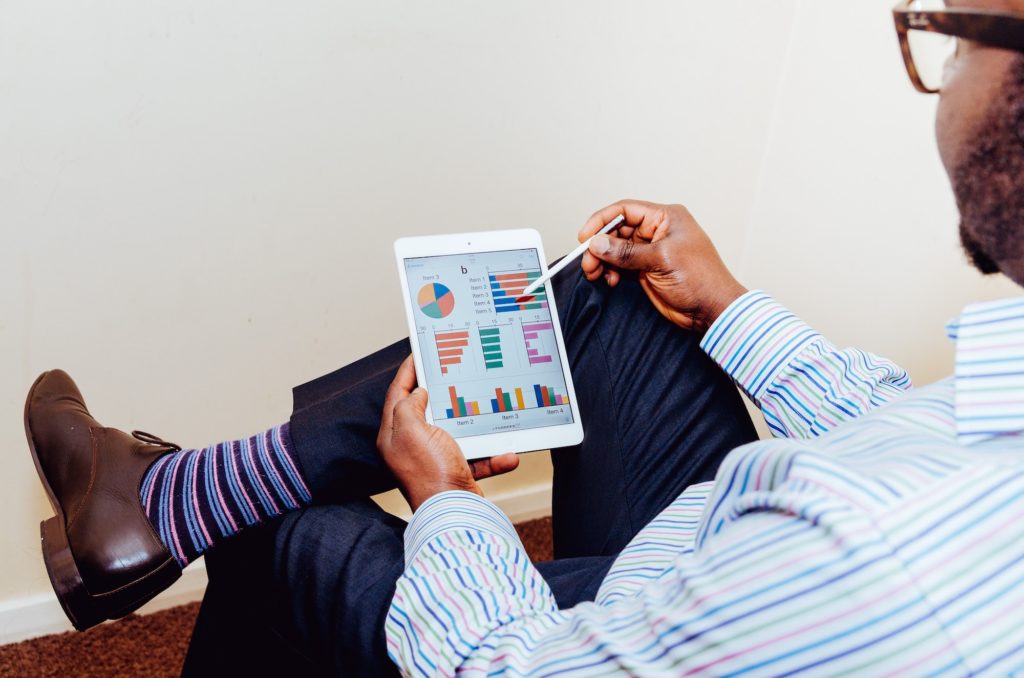 Man Looking at Analytics Graphs on a Ipad