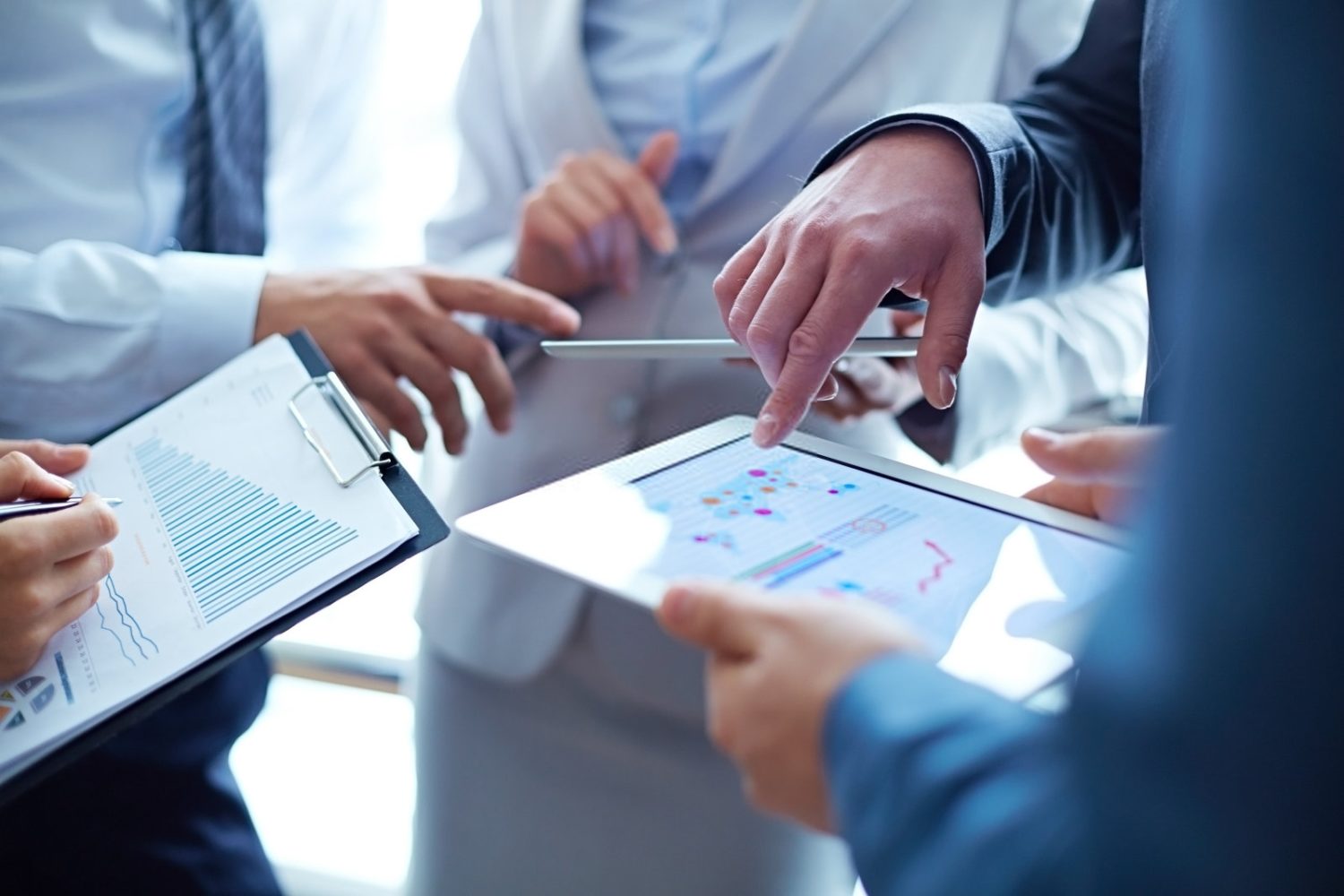 Business leaders with clipboards and data discussing plans