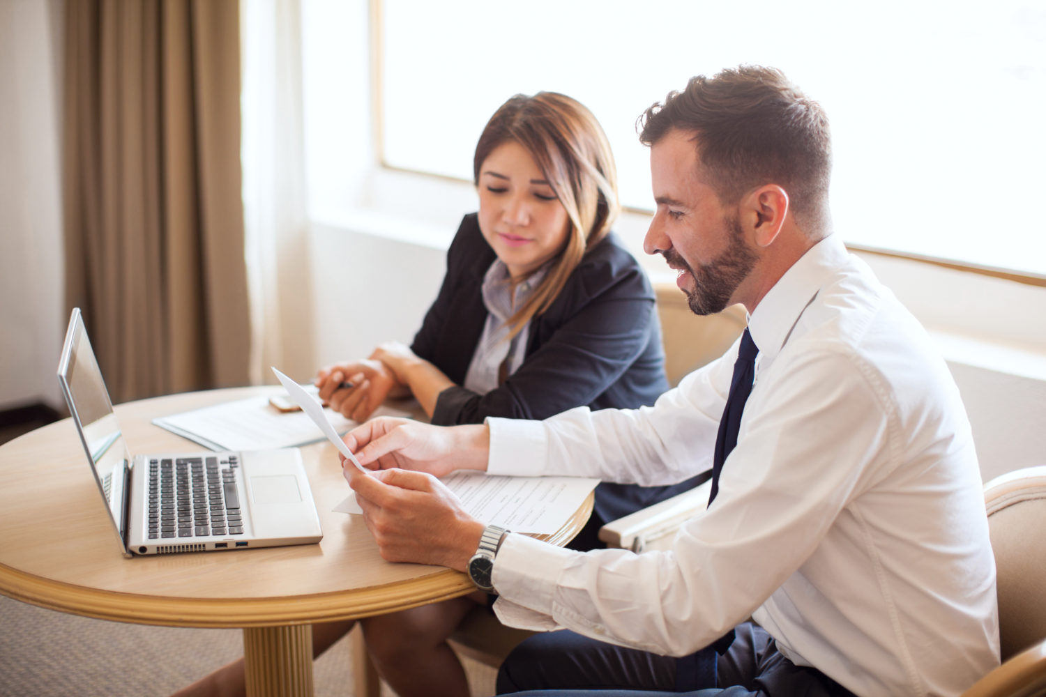 Man and a woman sitting at a table looking at a computer