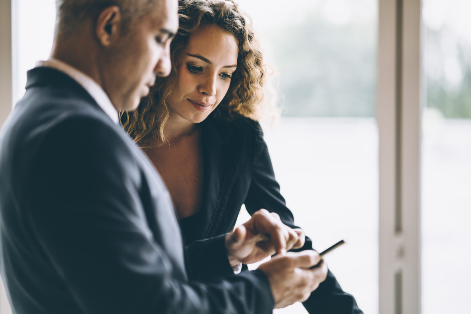 Woman looking over the shoulder of her colleague