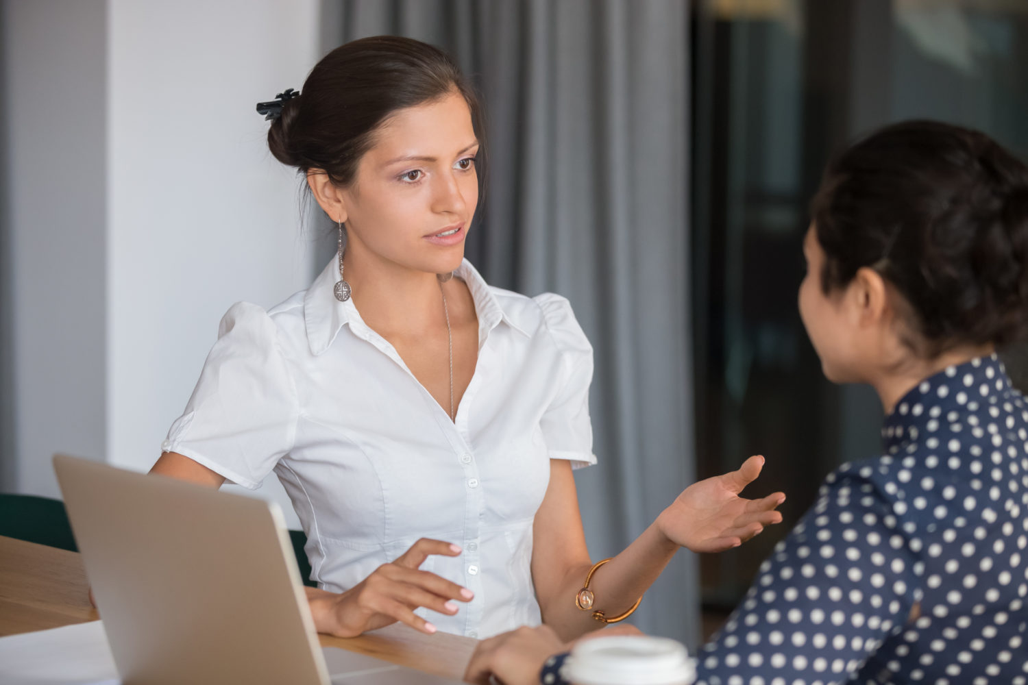 Female manager talking to employee with serious expression
