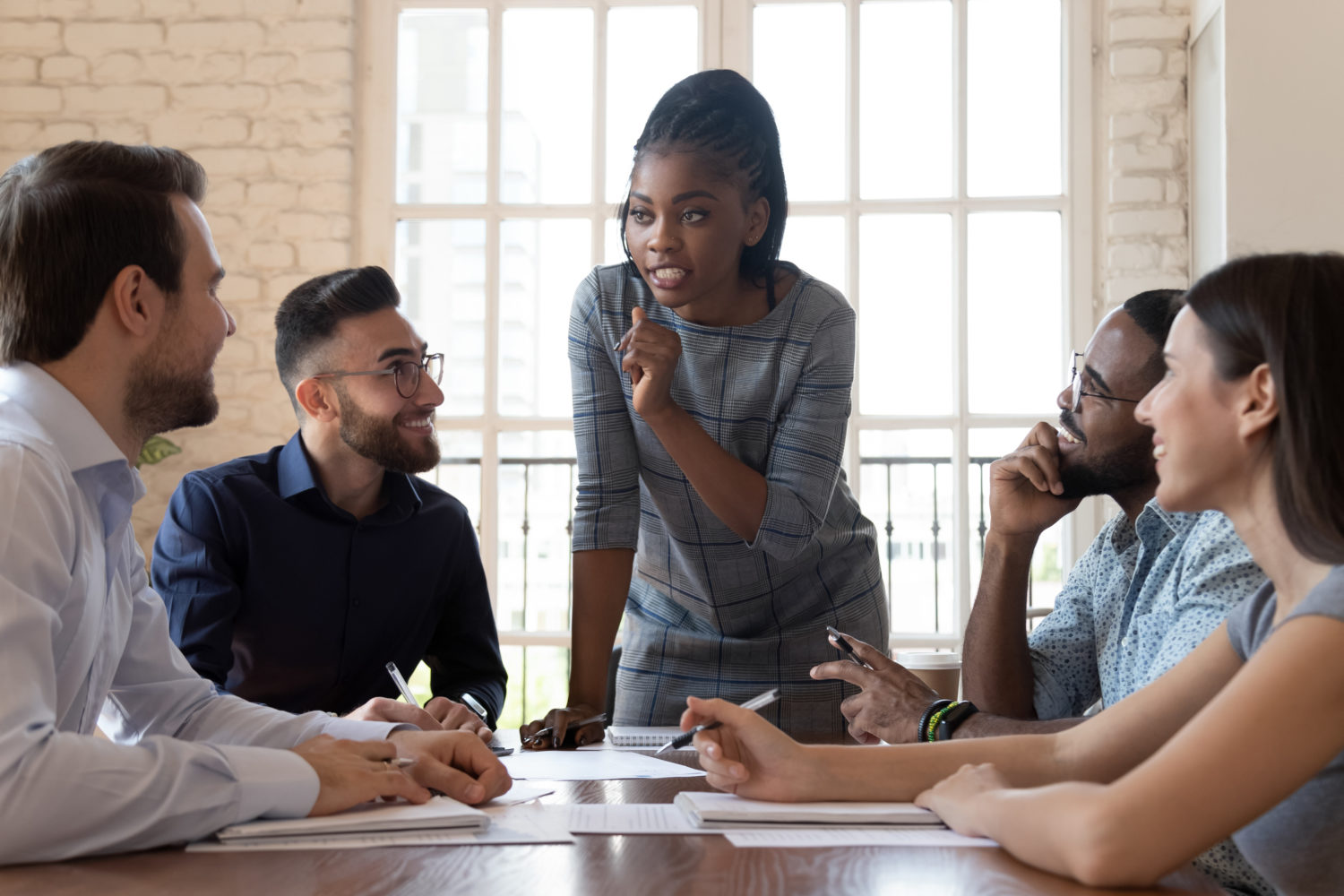 Female black executive talking to diverse employees at office briefing