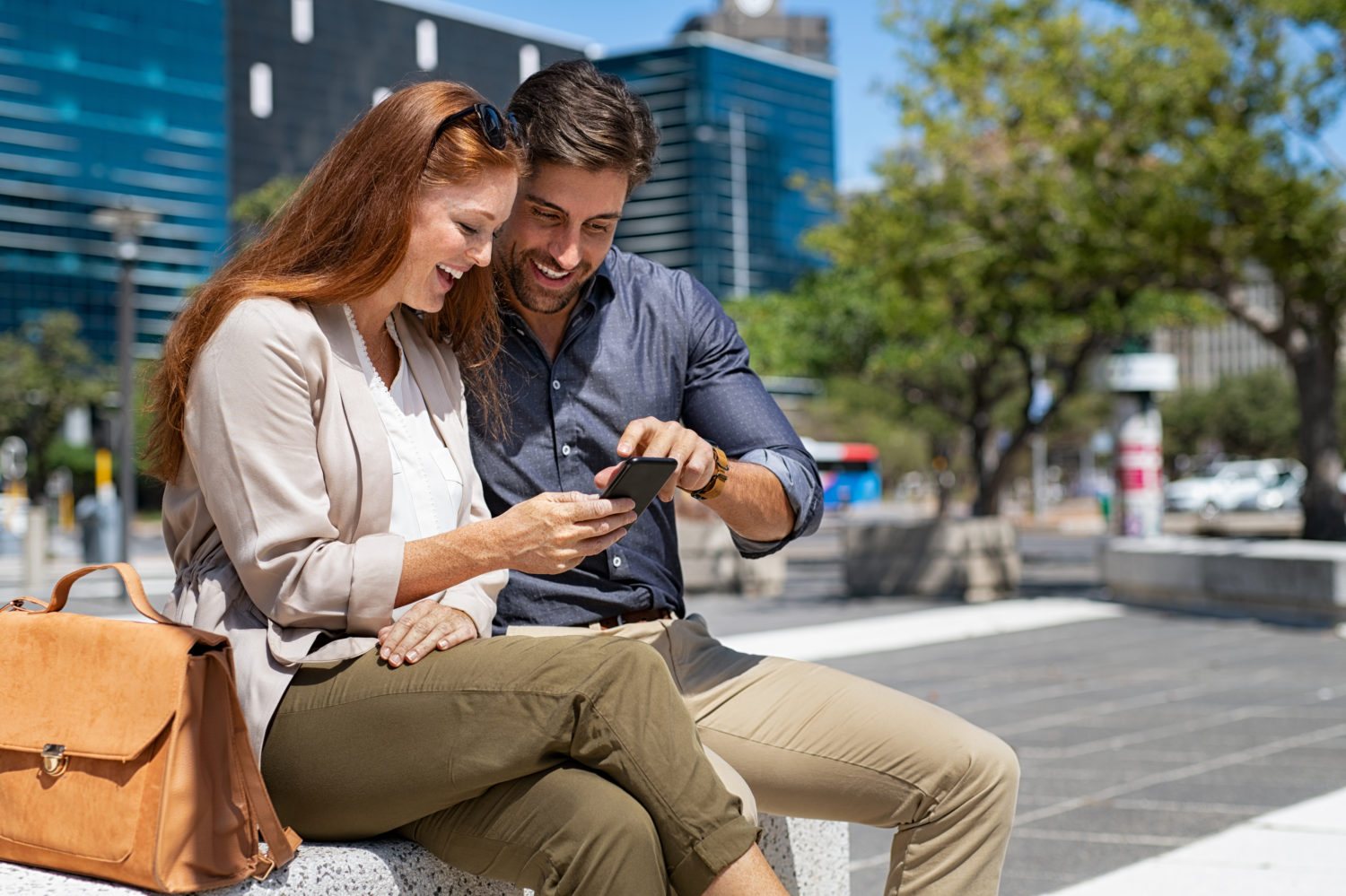 Red-haired woman and man looking excitedly at a phone