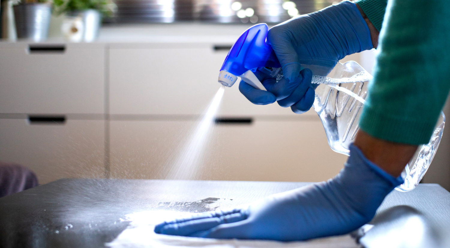 bottle spraying a cleaning fluid onto a surface