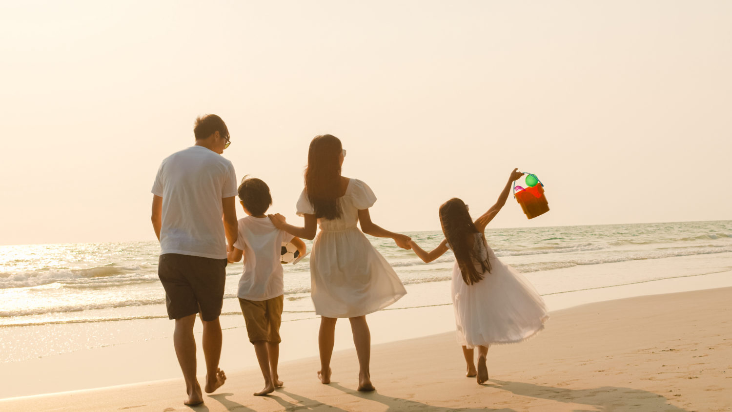 family of four walking along the beach