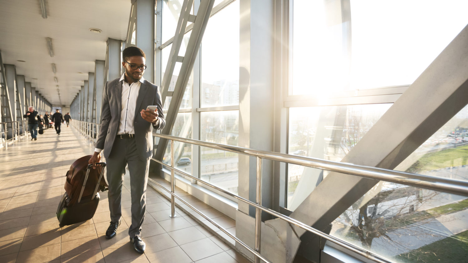 african american business traveler walking along indoor bridge