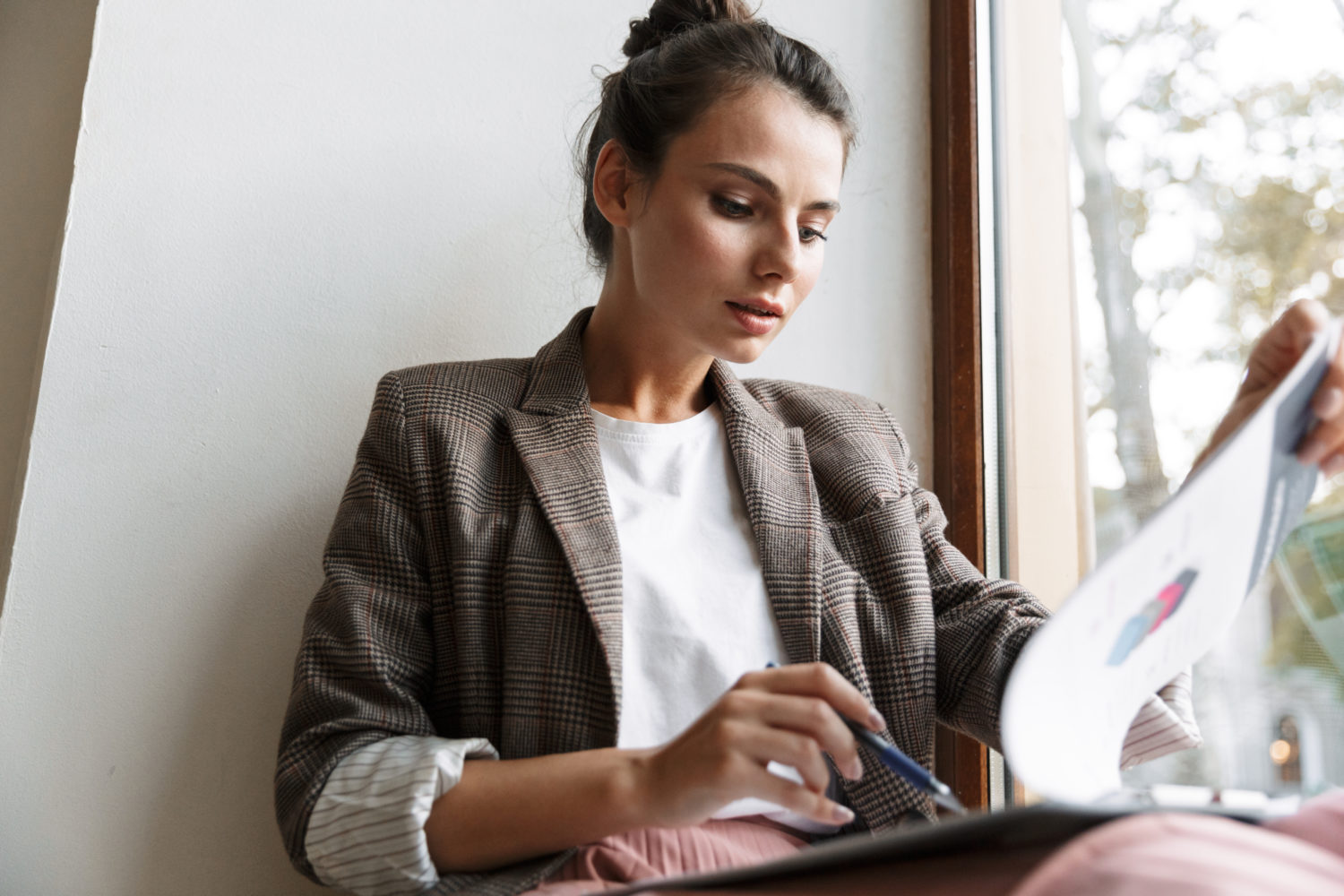 woman looking through data on a clipboard