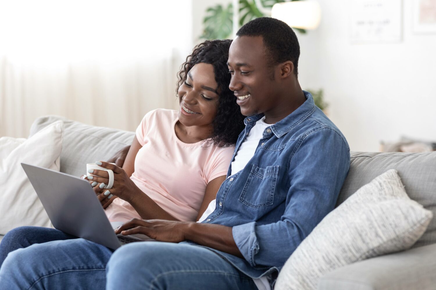 african american couple reading reviews on a laptop