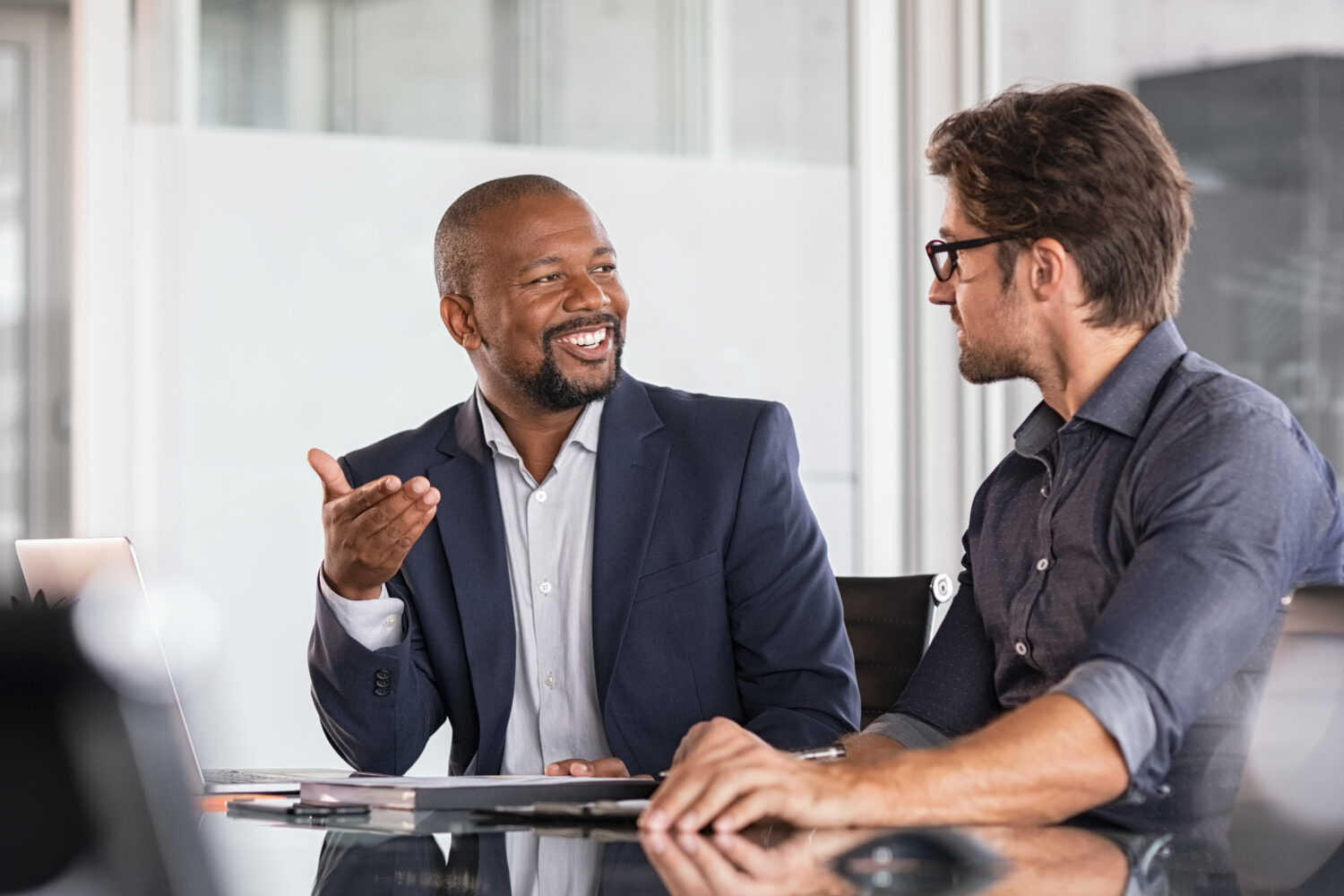 a black businessman has a happy discussion with a white businessman