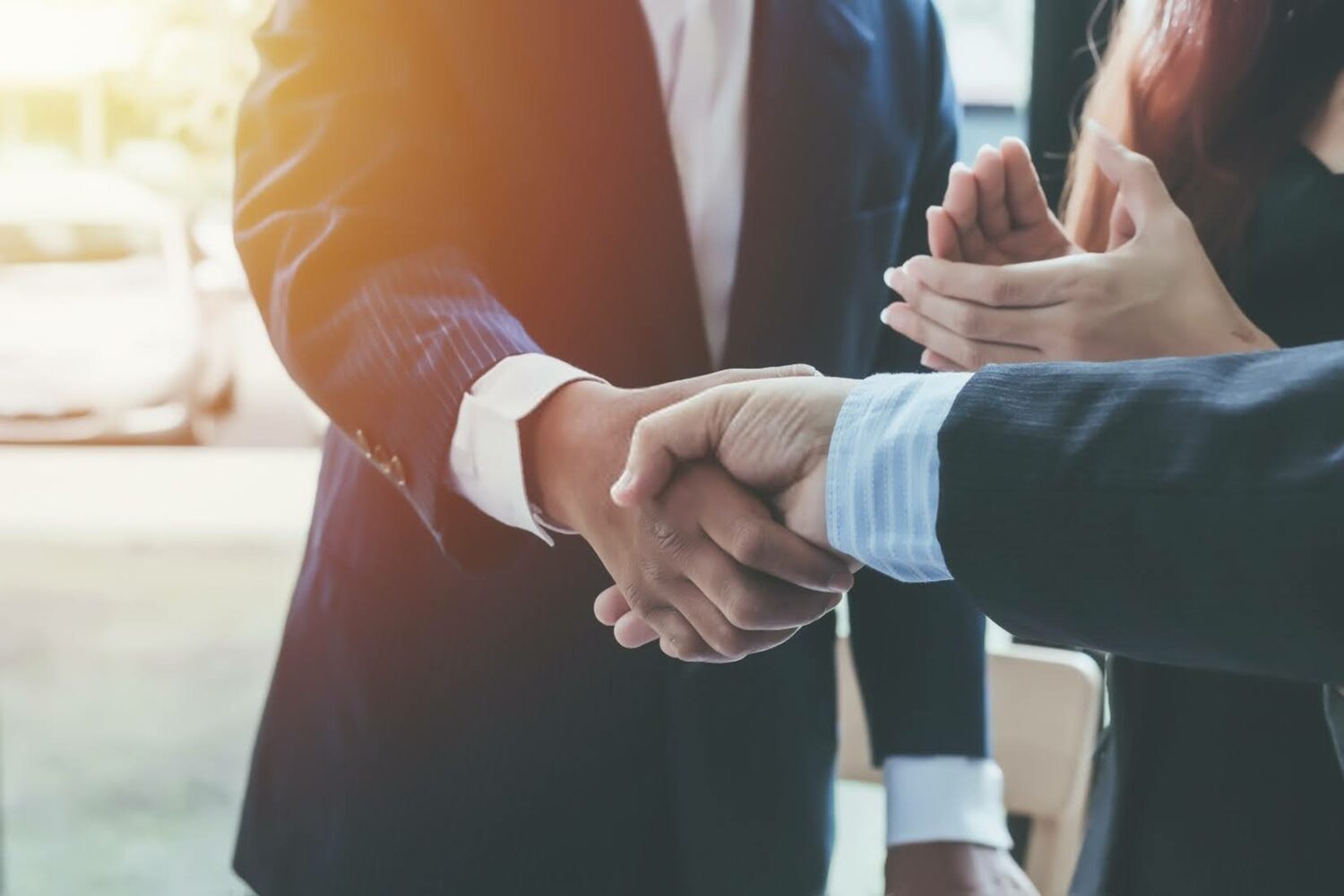 businesspeople wearing suits and shaking hands