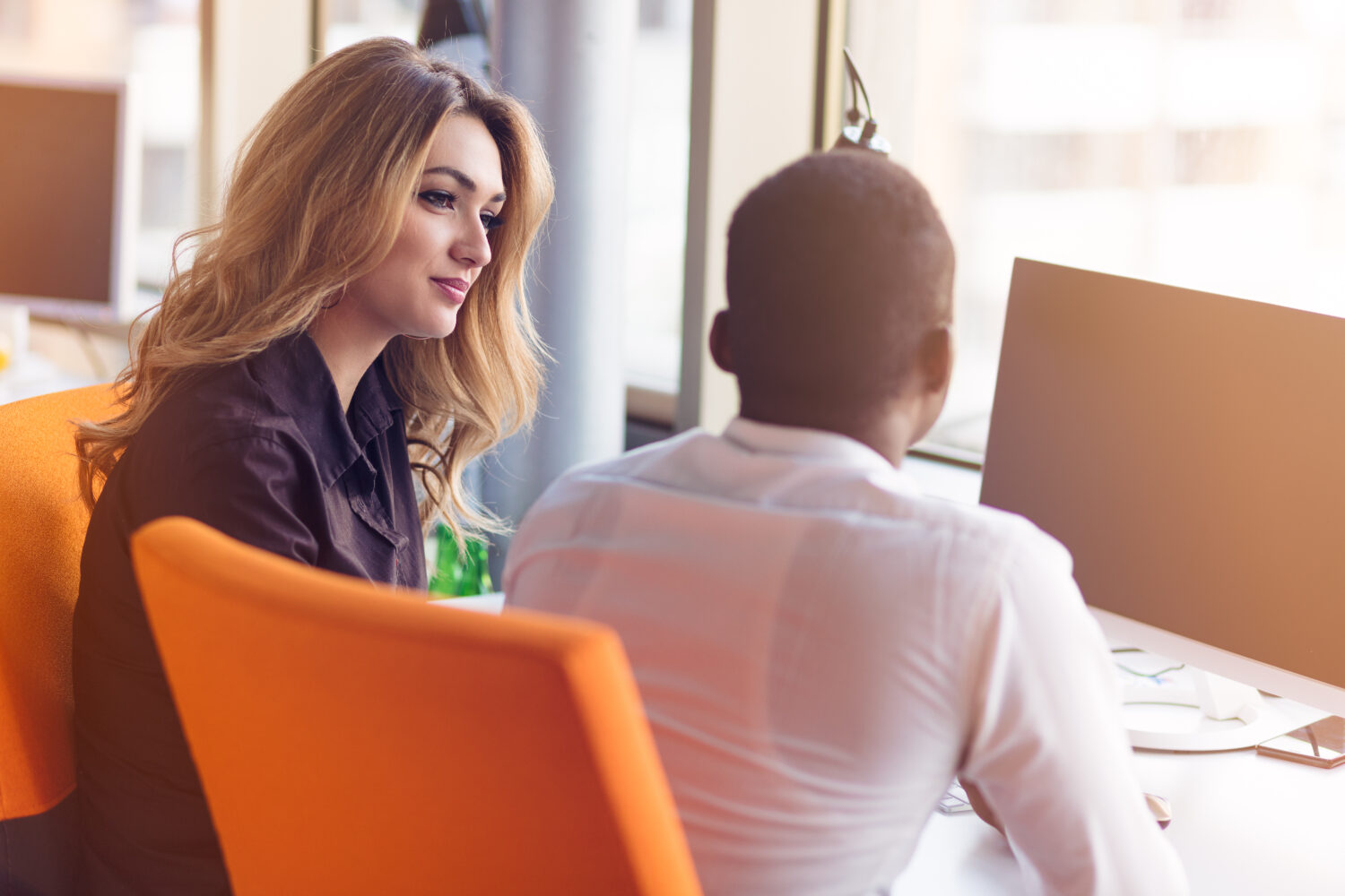 a woman sits and listens to her coworker