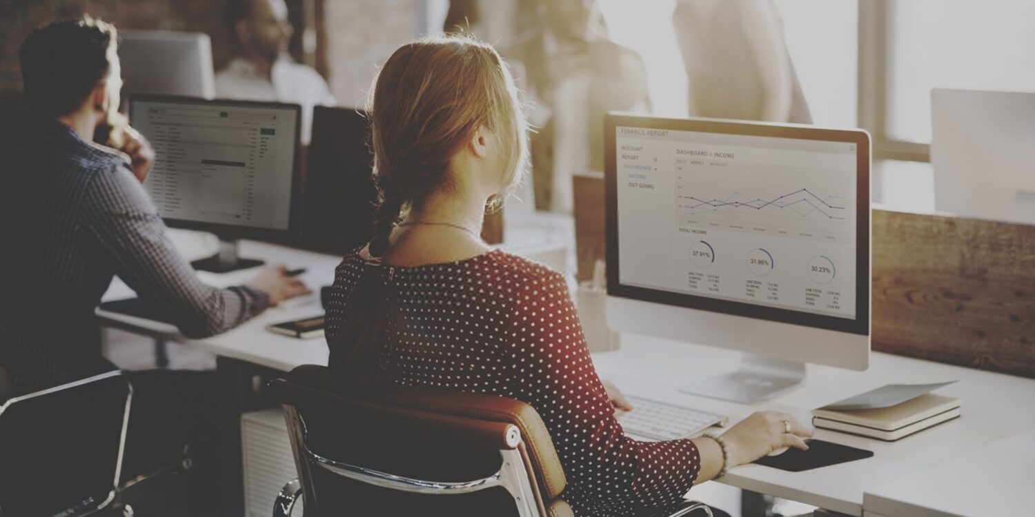 blonde woman facing her computer and working