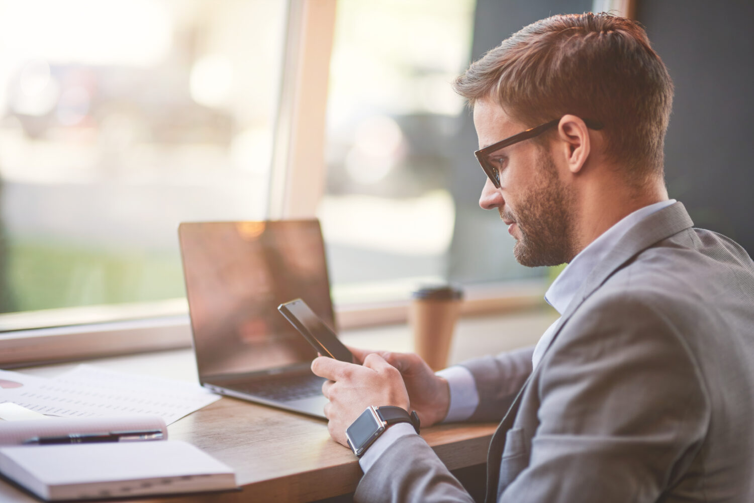 blonde glasses-wearing white man typing at his computer