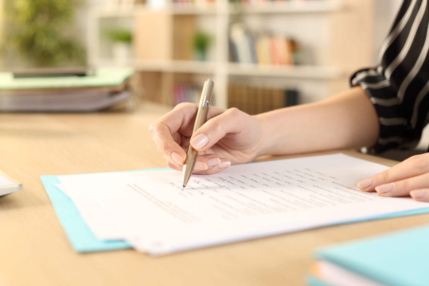 close up of woman's hand filling out paperwork