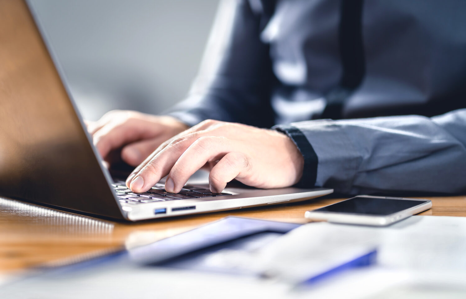 close-up of man's hands writing on a laptop