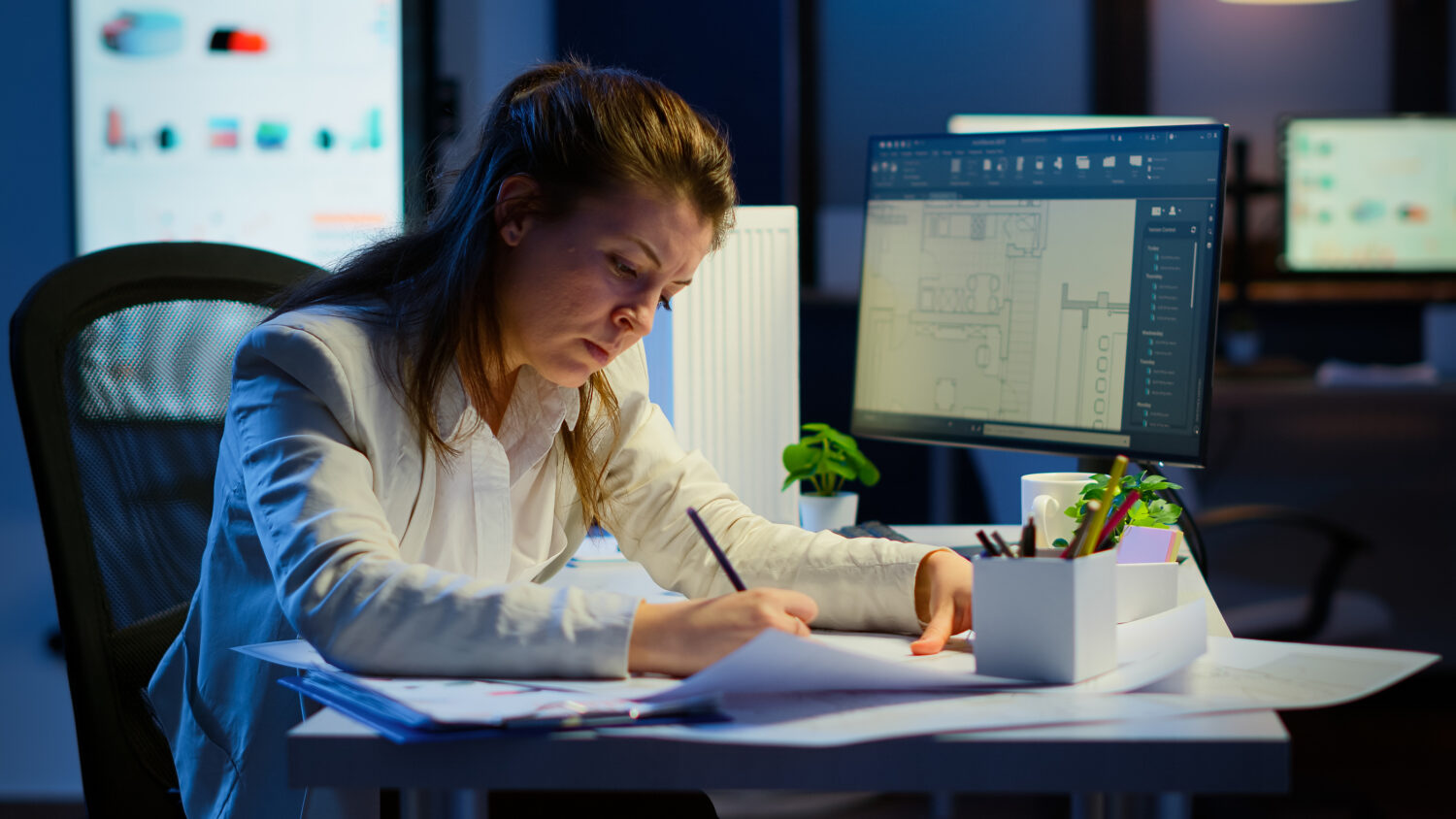 brown-haired woman working at her desk with papers