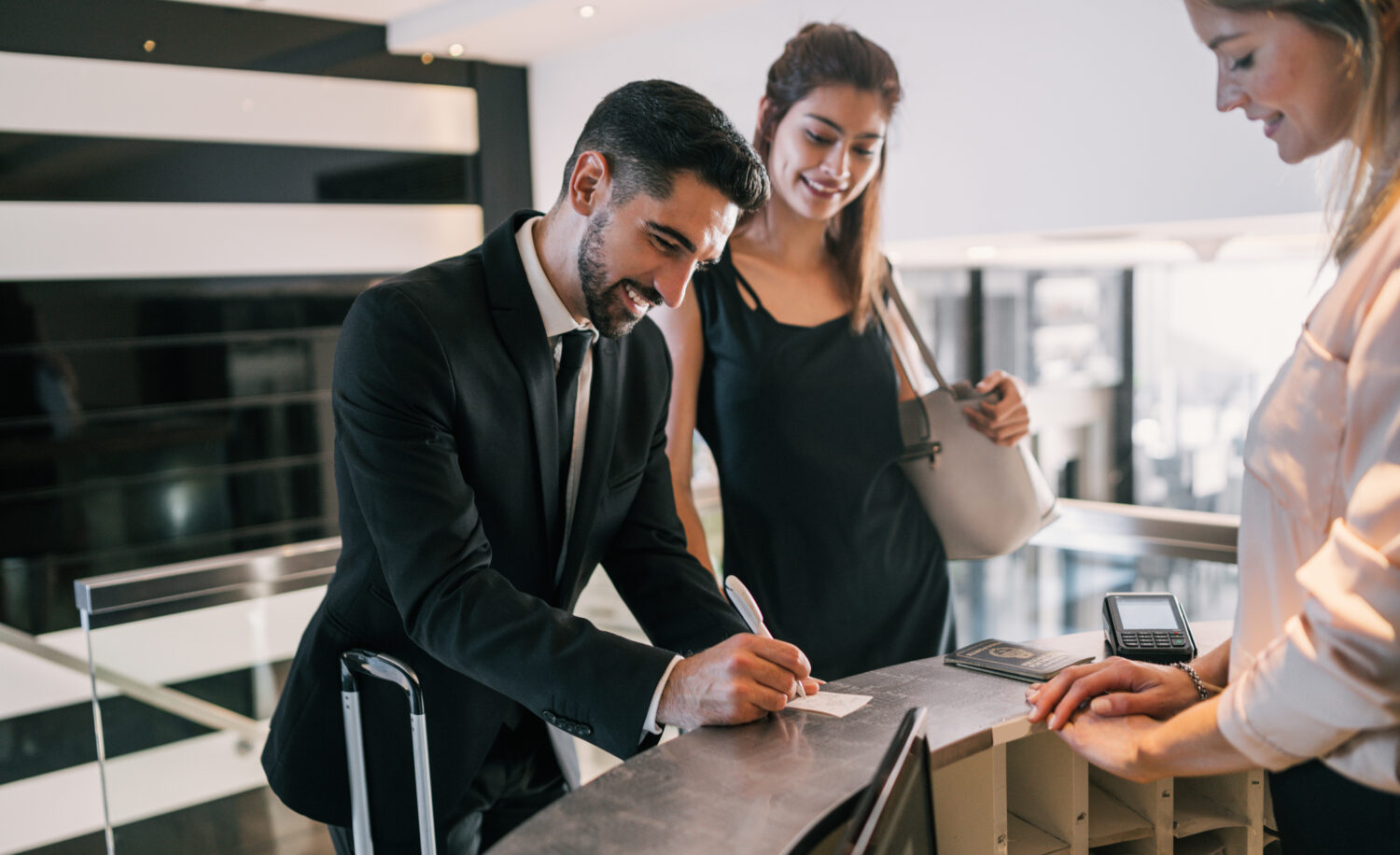 portrait of two young business people filling out a check-out survey