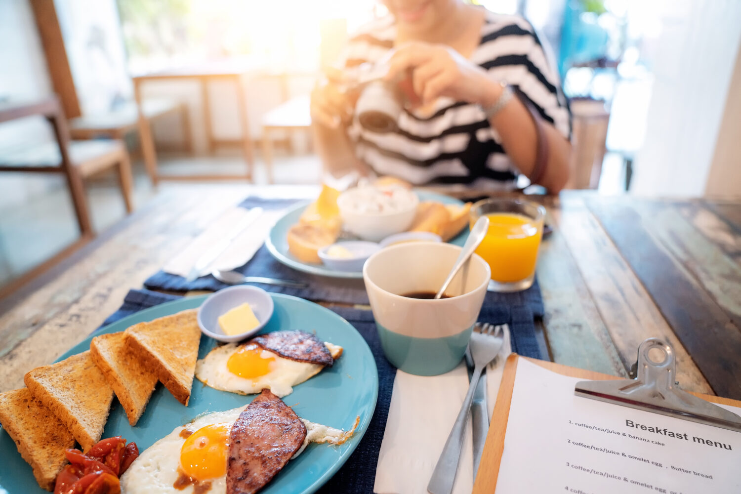 cropped photo of woman eating breakfast at a hotel restaurant