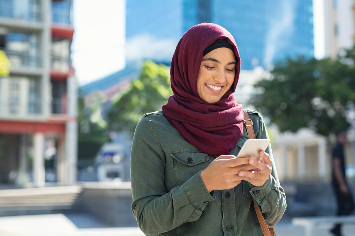 muslim woman using phone and smiling