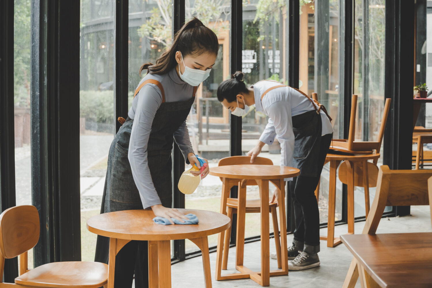 staff cleaning tables wearing face masks