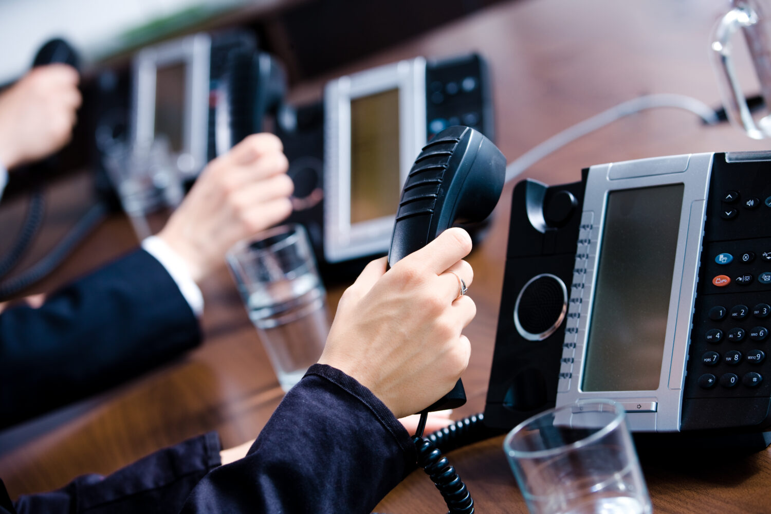 Close-up of hands holding landline phone receivers