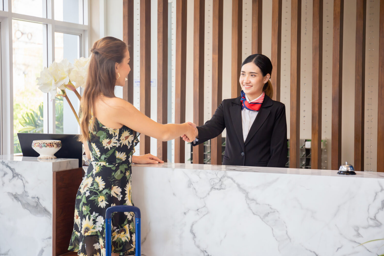 happy guest shaking hand with front desk receptionist