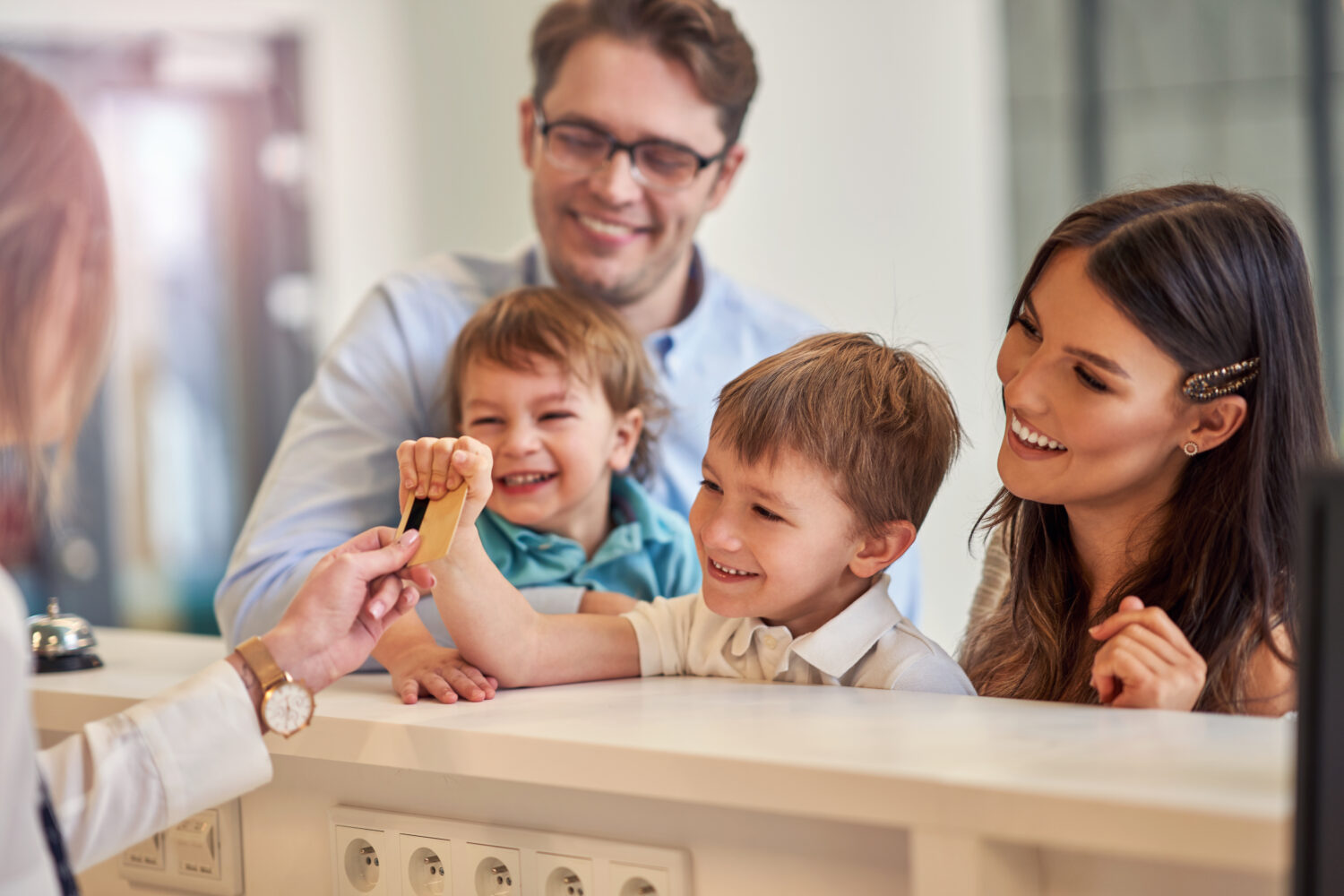 family happily checking out of a hotel