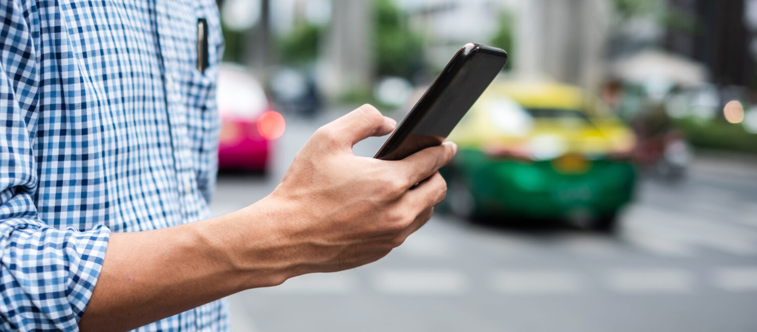 close cropped photo of a man's hand holding a phone