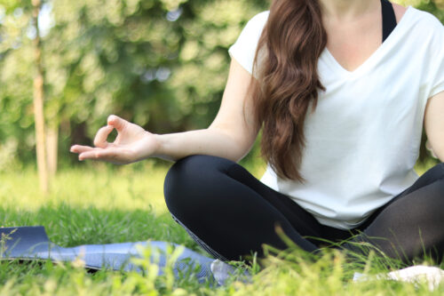 A Girl Sitting In A Meditation Pose On A Yoga Mat In The Lotus P